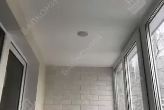 Отделка балкона декоративным камнем, ламинат и натяжной потолок
